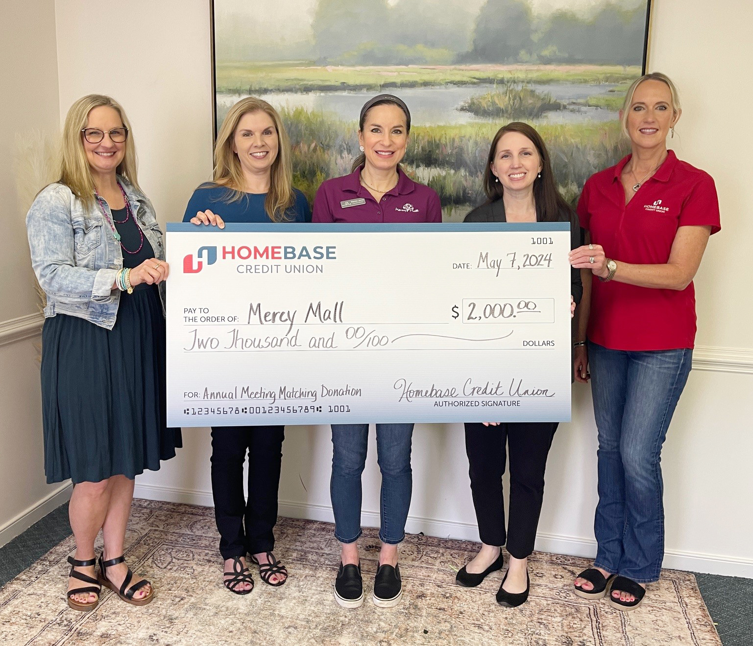 ladies holding large check